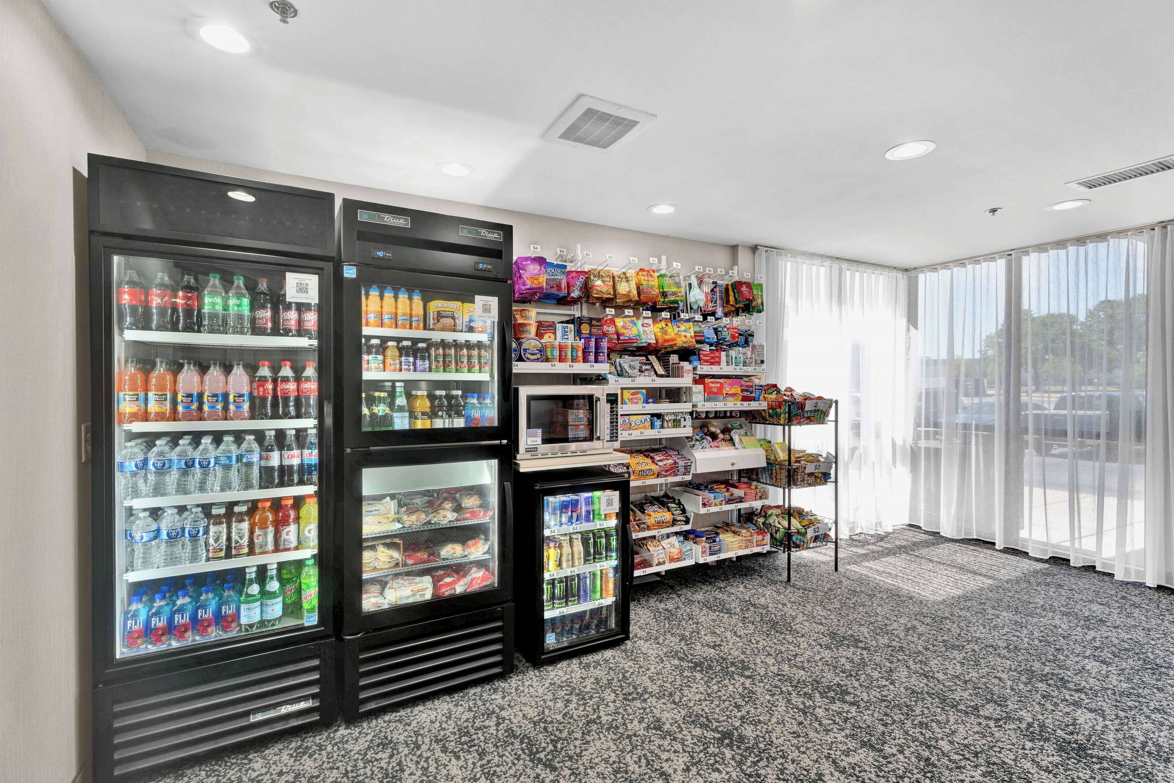 A hotel lobby with a seating area, a vending machine, and a snack bar.