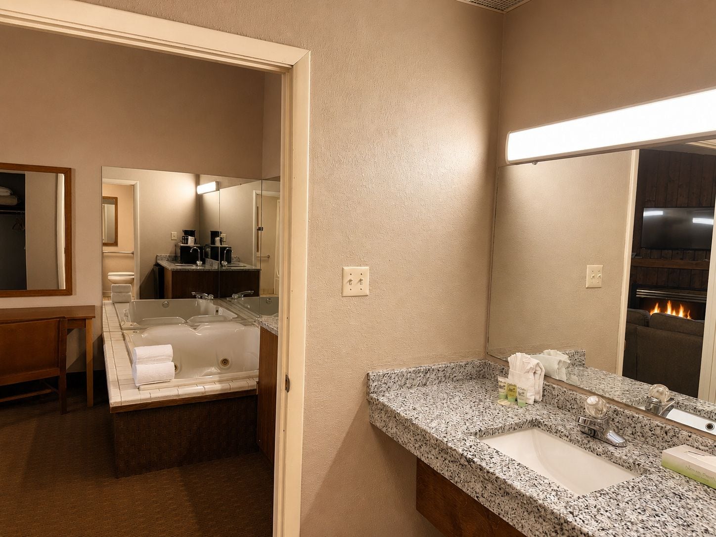 Un baño de hotel con una bañera, un lavabo y un espejo.