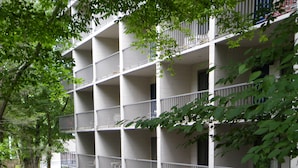 Un hotel de varios pisos con balcones que dan a un río serpenteante.
