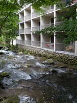 A multi-story hotel with balconies overlooking a flowing river.