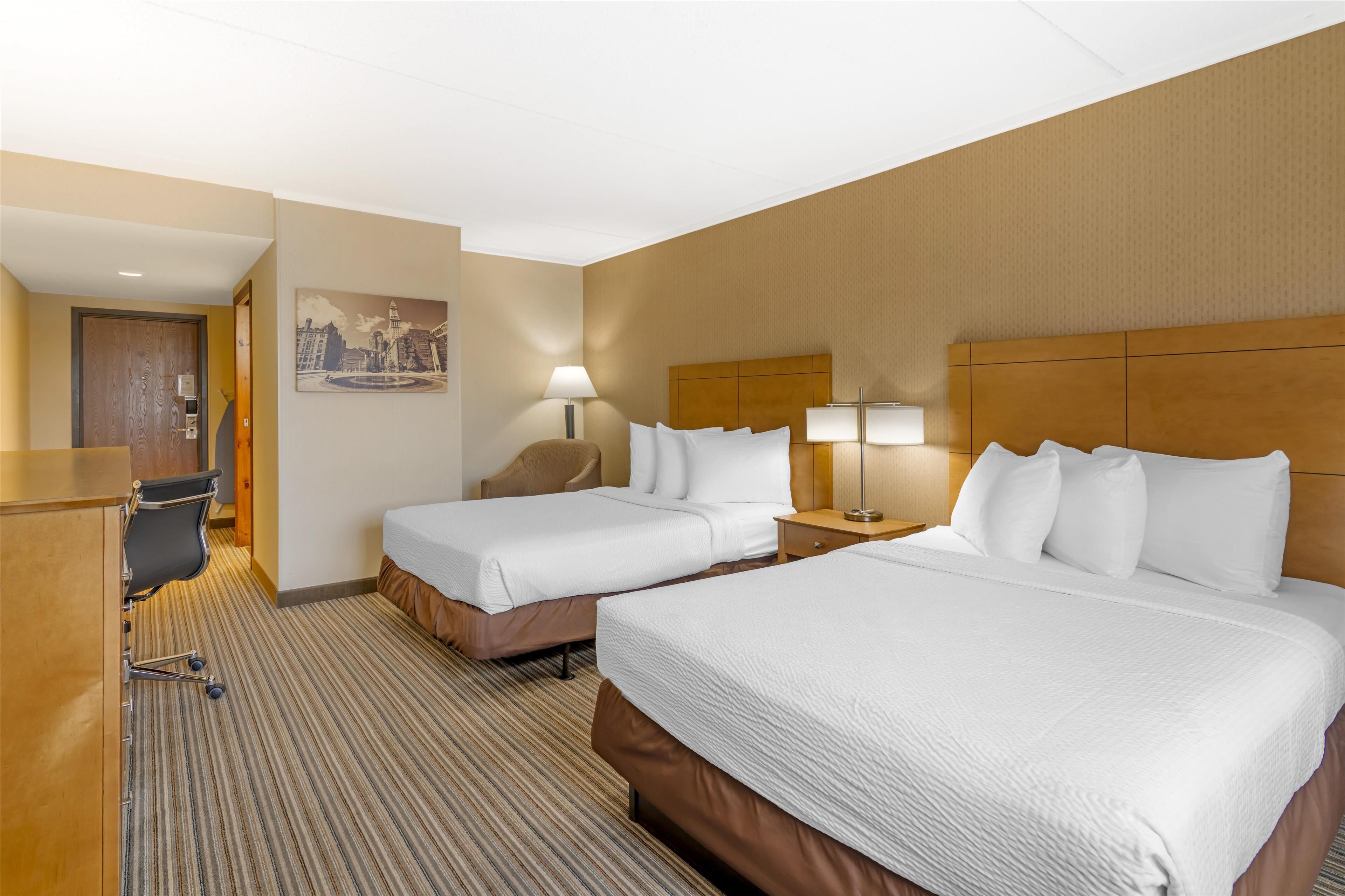 Una habitación de hotel con dos camas, un escritorio y una silla.