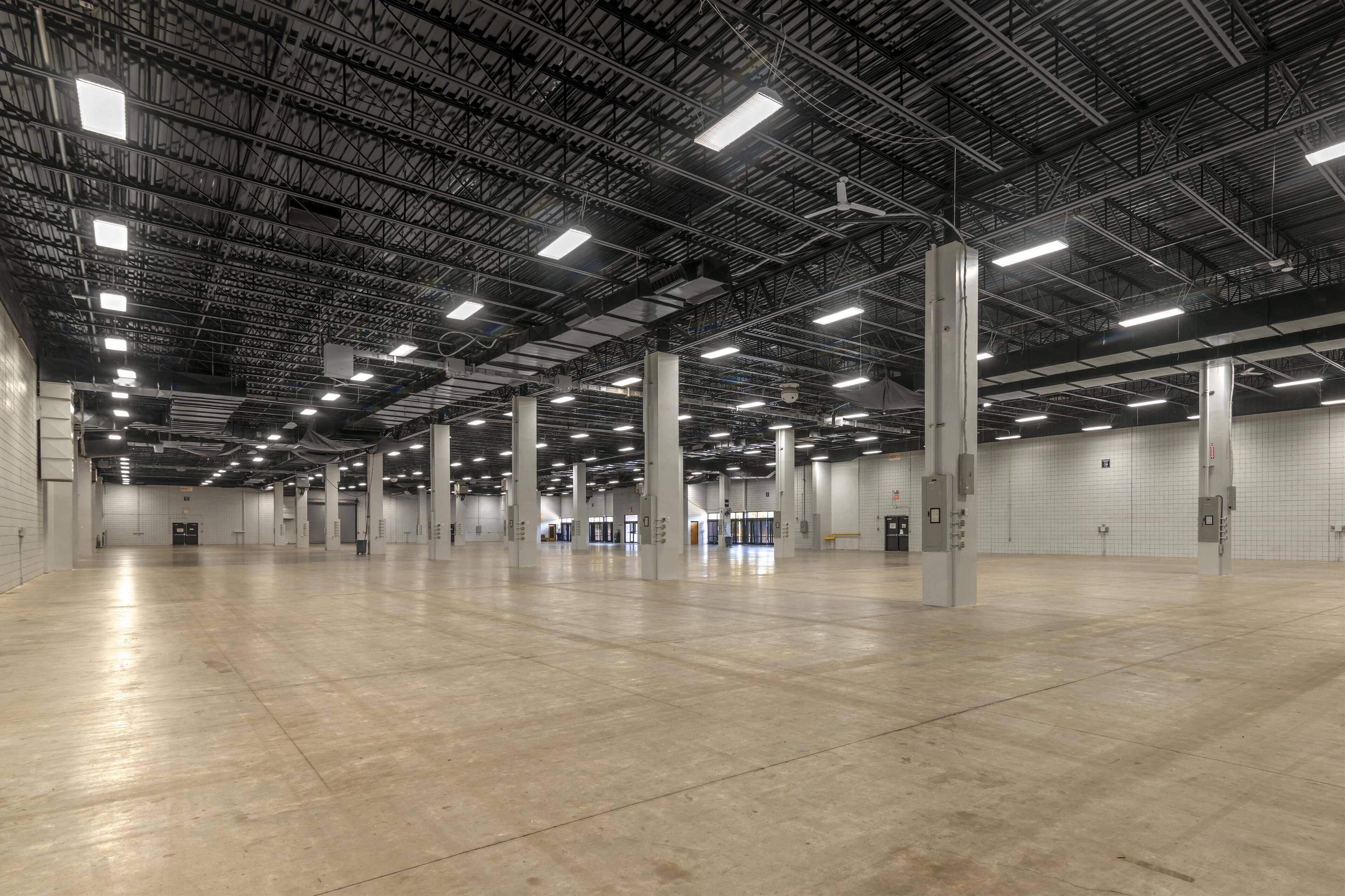 A spacious indoor area with high ceilings and industrial lighting.