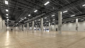 A spacious indoor area with high ceilings and industrial lighting.