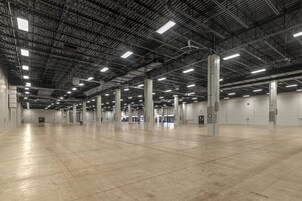 A spacious indoor area with high ceilings and industrial lighting.