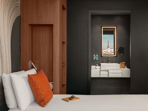 A modern bathroom with a white sink, a framed picture of a cityscape, and a dark wall. - Novotel Paris Vaugirard Montparnasse (Paris)