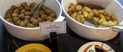 Dos porciones de falafel, una con la etiqueta '100% Falafel Vegetal', sobre una mesa con un letrero.
