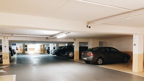 Un estacionamiento con varios automóviles aparcados en sus espacios designados.