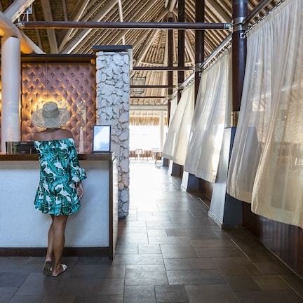 A reception area with a counter, a decorative wall, and a view of the corridor.