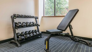 A gym with a bench and a rack of dumbbells.