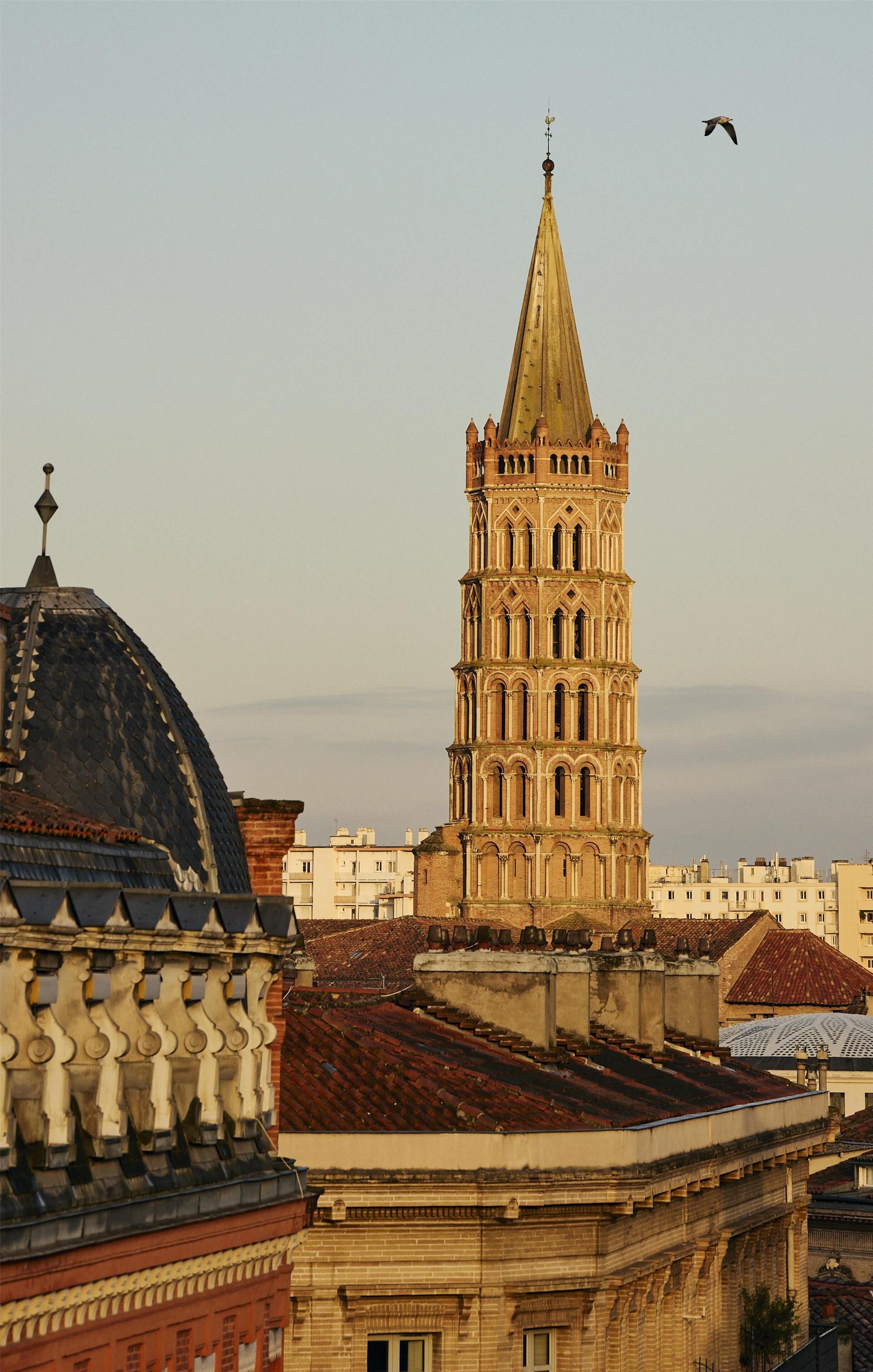 A historic tower with a pointed roof and a dome in the foreground.