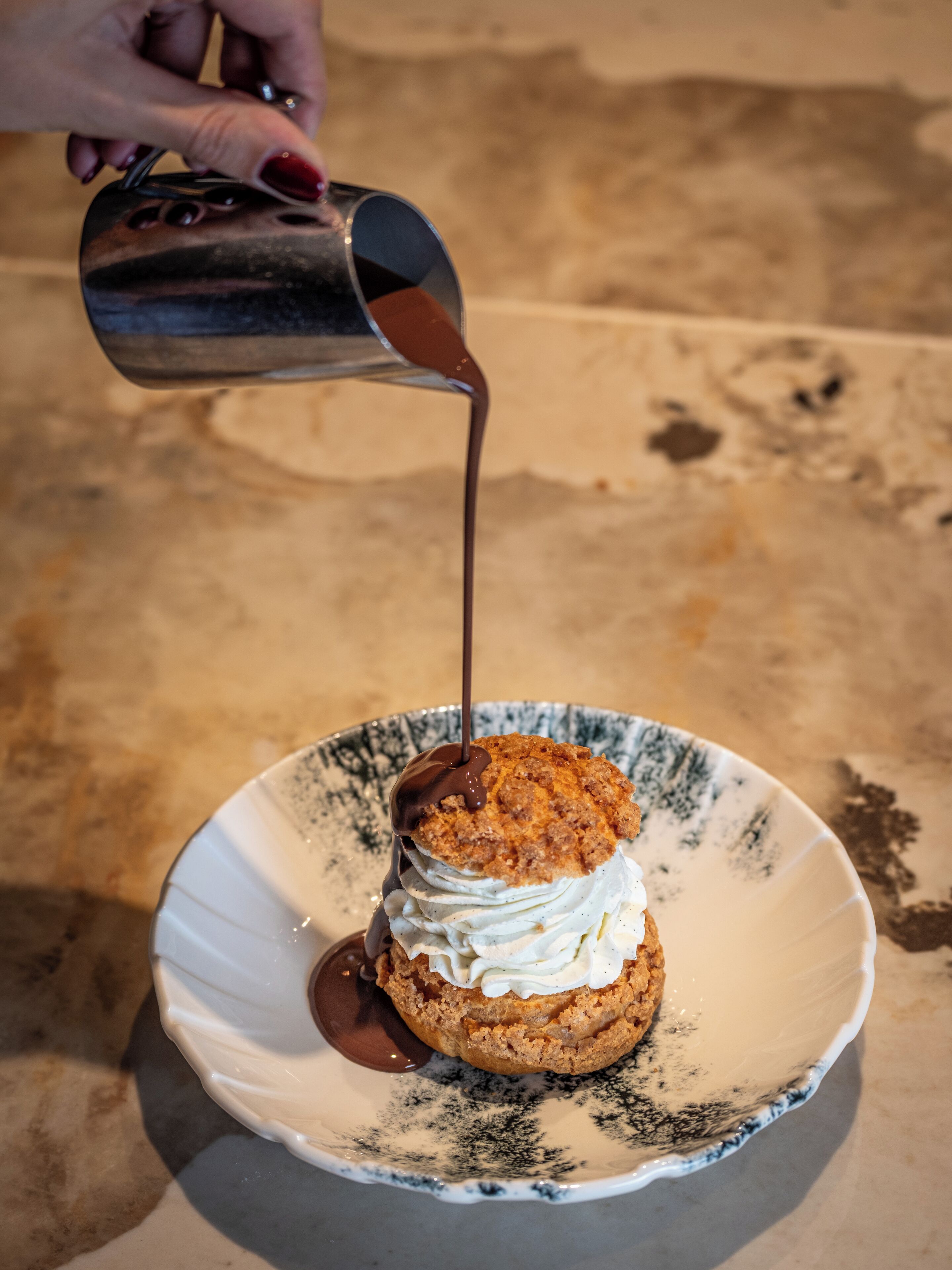 Un dessert agrémenté de crème fouettée et nappé d’une sauce.