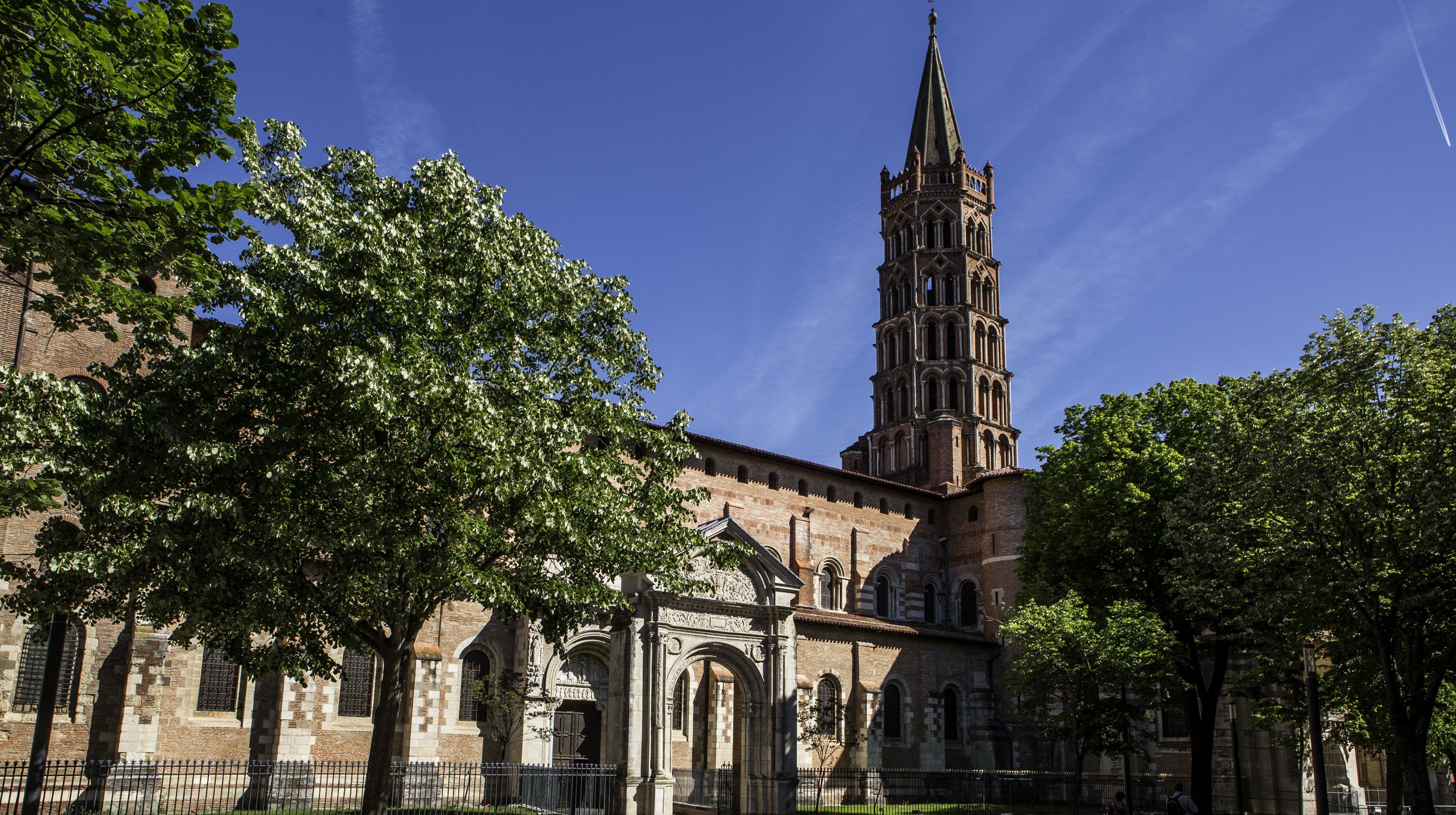 Une église historique dotée d’un haut clocher et de fenêtres en arc de cercle.