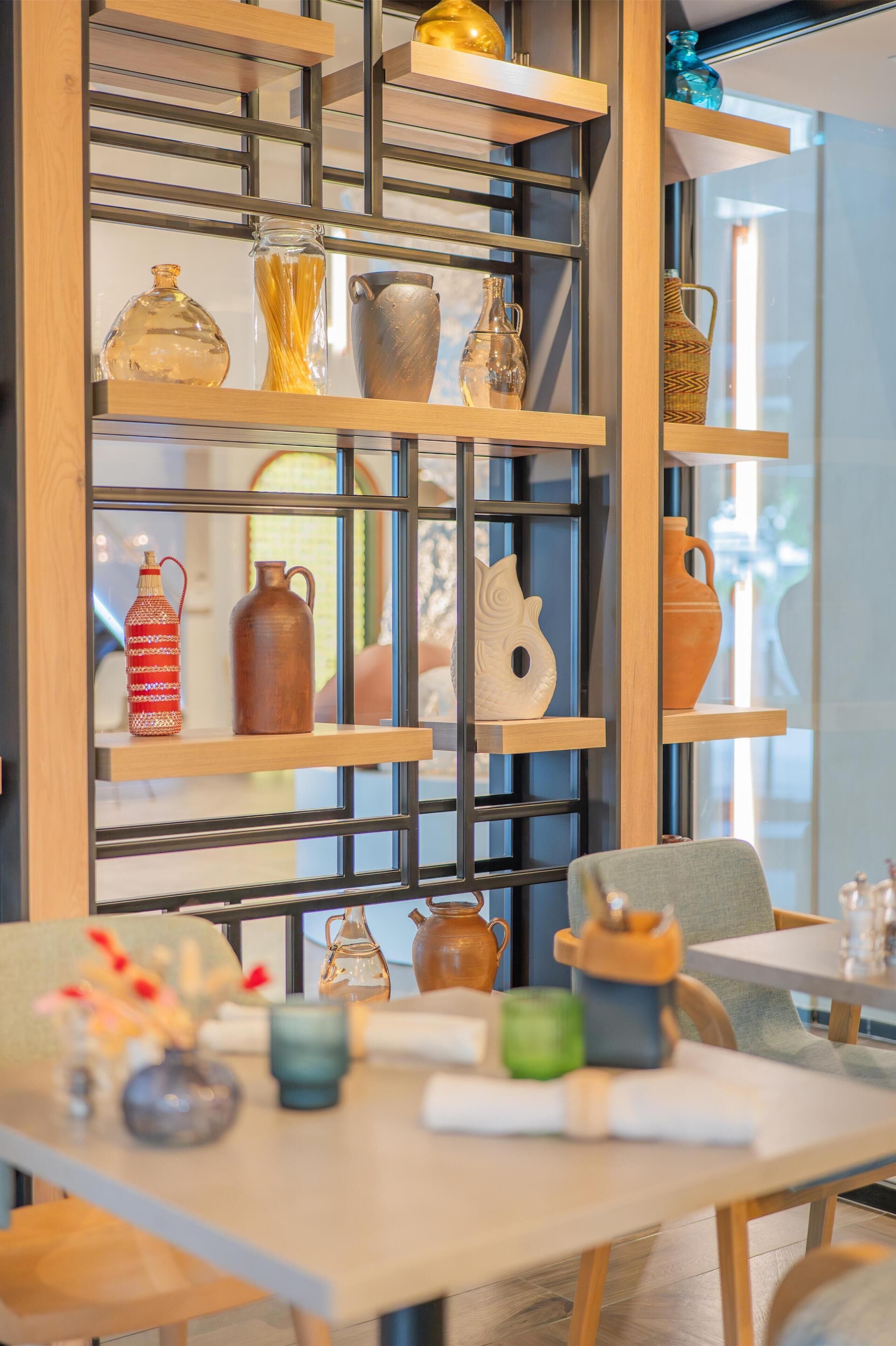 A room with a wooden bookshelf displaying various ceramic items.