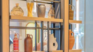 A room with a wooden bookshelf displaying various ceramic items.