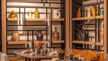 Un intérieur moderne avec des meubles en bois, des étagères en verre où sont exposés des objets décoratifs, et une disposition épurée et bien organisée.