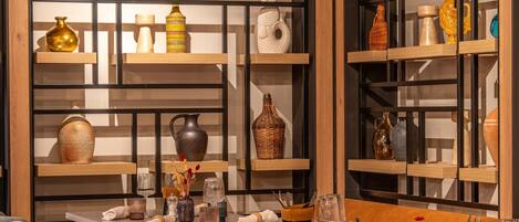 A modern interior with wooden furniture, glass shelves displaying decorative items, and a clean, organized layout.