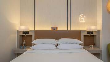 Habitación de hotel con una cama grande, dos mesitas de noche y un cabecero con una lámpara.