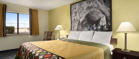 Habitación de hotel con una cama grande, dos lámparas de noche, un cuadro grande en la pared y una ventana con cortinas.