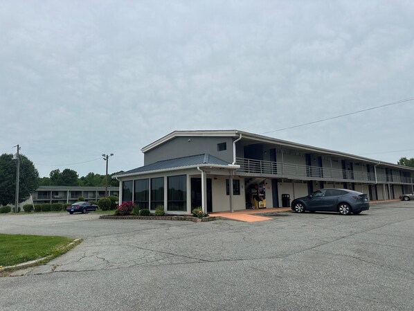 Un motel de dos pisos con entrada cubierta y estacionamiento.
