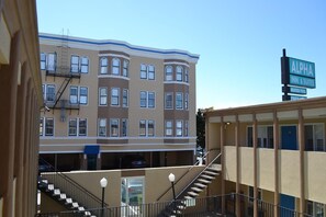 A multi-story building with a sign for 'ALPHA INN & SUITES' indicating a hotel. - Alpha Inn & Suites (San Francisco)