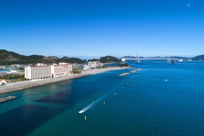 A coastal hotel with a view of the sea and a bridge in the distance. - AoAwo Naruto Resort (Naruto)