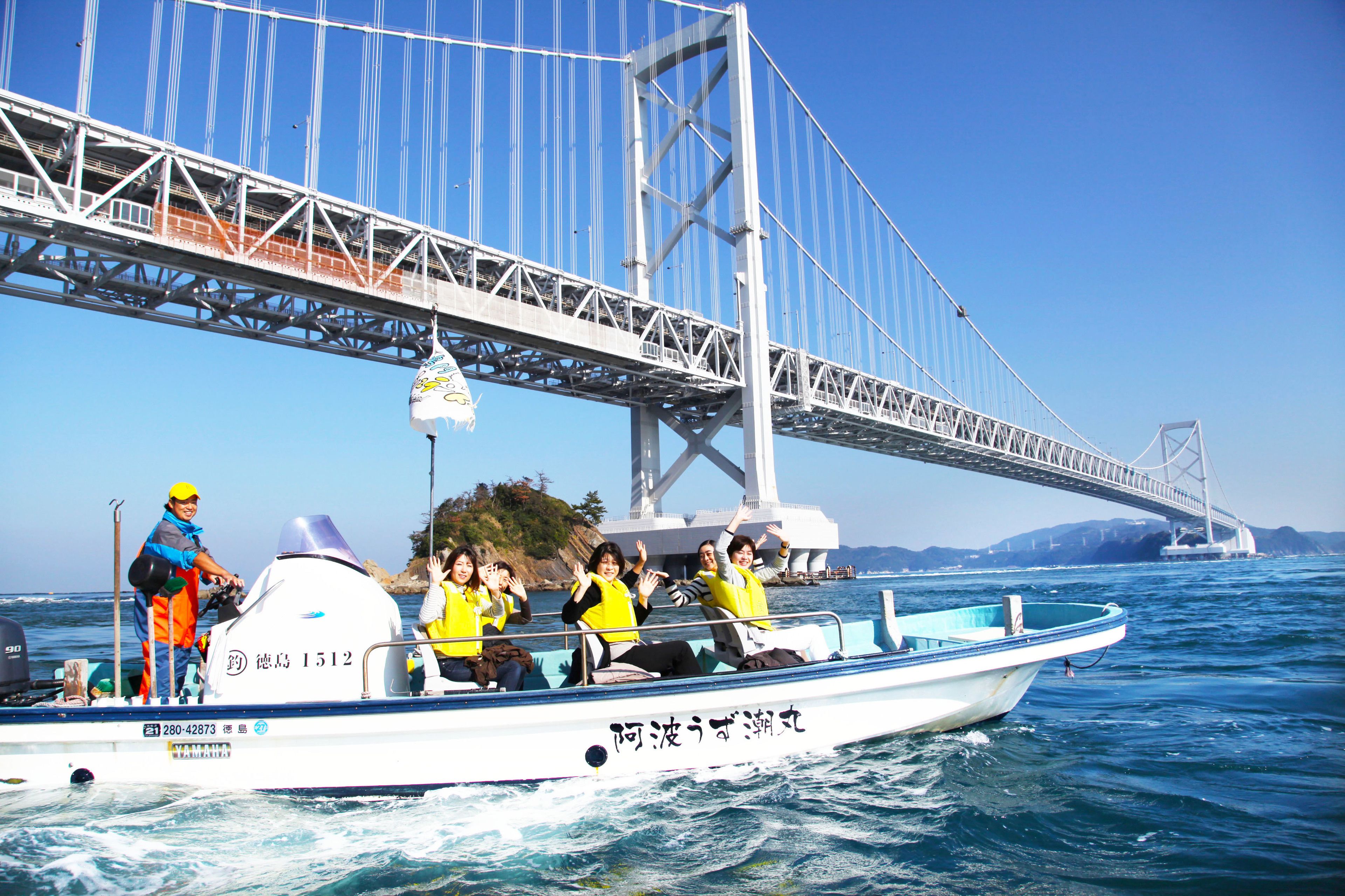 Un bateau transportant des passagers qui profitent d’une promenade sous un pont.