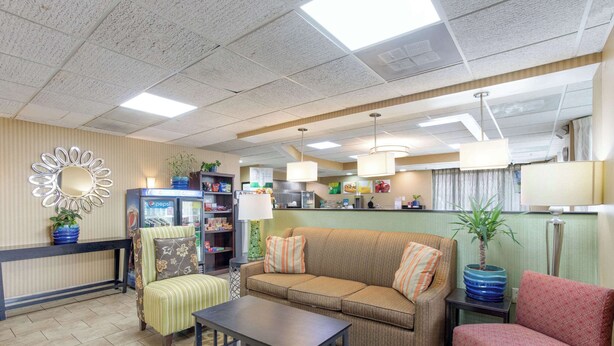 A lobby with a sofa, armchairs, a coffee table, a refrigerator, and a potted plant. - Quality Inn Lebanon (Lebanon)