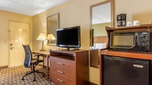 A hotel room with a television, a desk with a chair, a refrigerator, a microwave, and a coffee maker. - Quality Inn Lebanon (Lebanon)