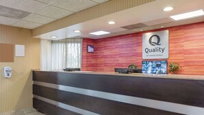 A hotel reception area with a reception desk, a sign reading "Quality by Choice Hotels," and a digital screen above the desk. - Quality Inn Lebanon (Lebanon)
