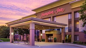 Entrada de un hotel Hampton Inn con un vestíbulo cubierto, señalización clara y una entrada acogedora.