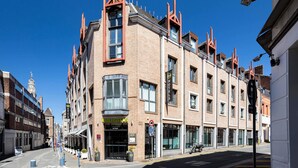 Un hotel con ubicación en esquina, amplias ventanas y fachada de ladrillo.