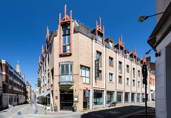 A hotel with a corner location, large windows, and a brick facade. - B&B HOTEL Arras Centre Les Places (Arras)
