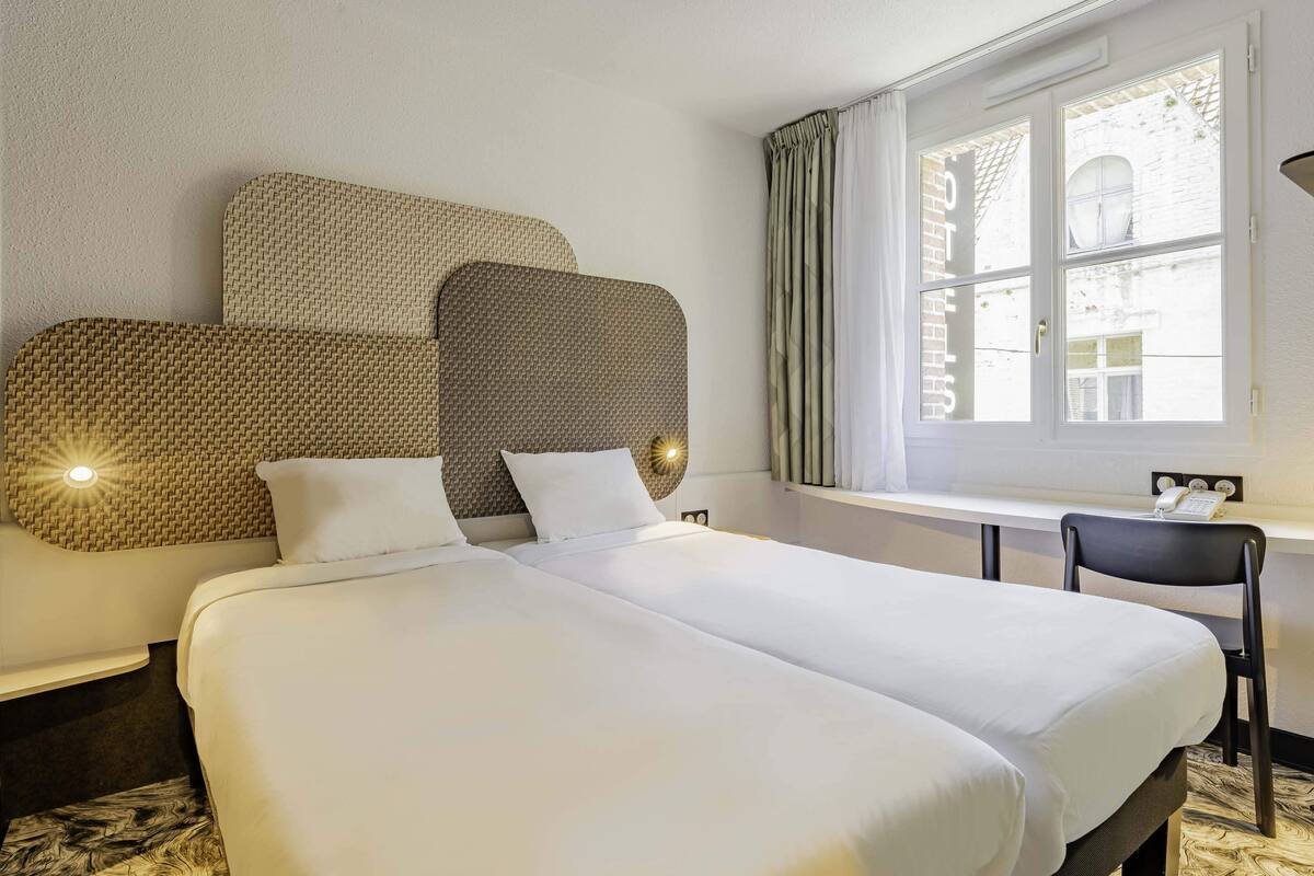 Una habitación de hotel con una cama grande, un escritorio y una silla.