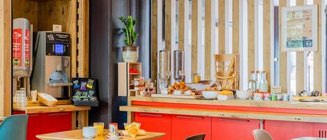 A modern cafe with a wooden counter, red cabinets, and a coffee machine.