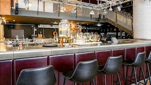 A bar area with a high counter, stools, and a large jar of ice. - Max Brown Hotel 5th District, part of Sircle Collection (Vienna)