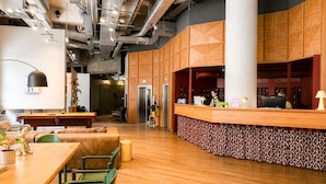 A modern lobby with a reception desk, seating area, and a staircase leading to an upper level. - Max Brown Hotel 5th District, part of Sircle Collection (Vienna)