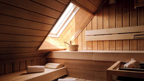 A wooden sauna with benches, a window, and a towel rack. - Max Brown Hotel 5th District, part of Sircle Collection (Vienna)