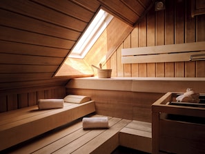 A wooden sauna with benches, a window, and a towel rack. - Max Brown Hotel 5th District, part of Sircle Collection (Vienna)