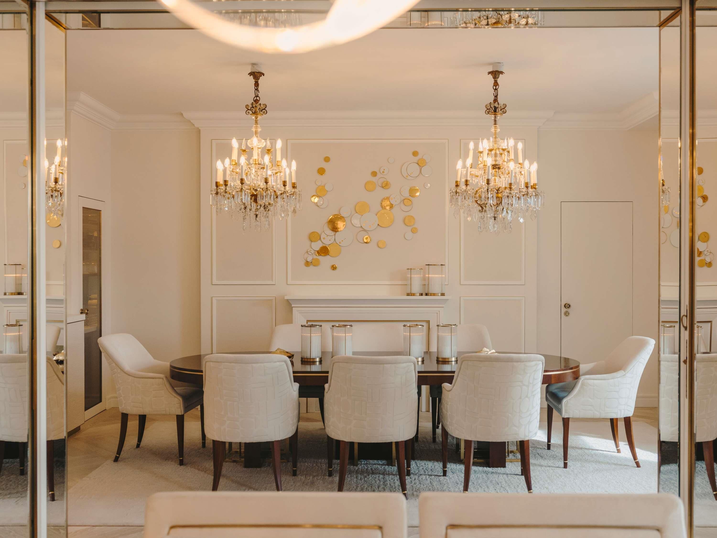 Un comedor con candelabro, chimenea y una obra de arte en la pared.