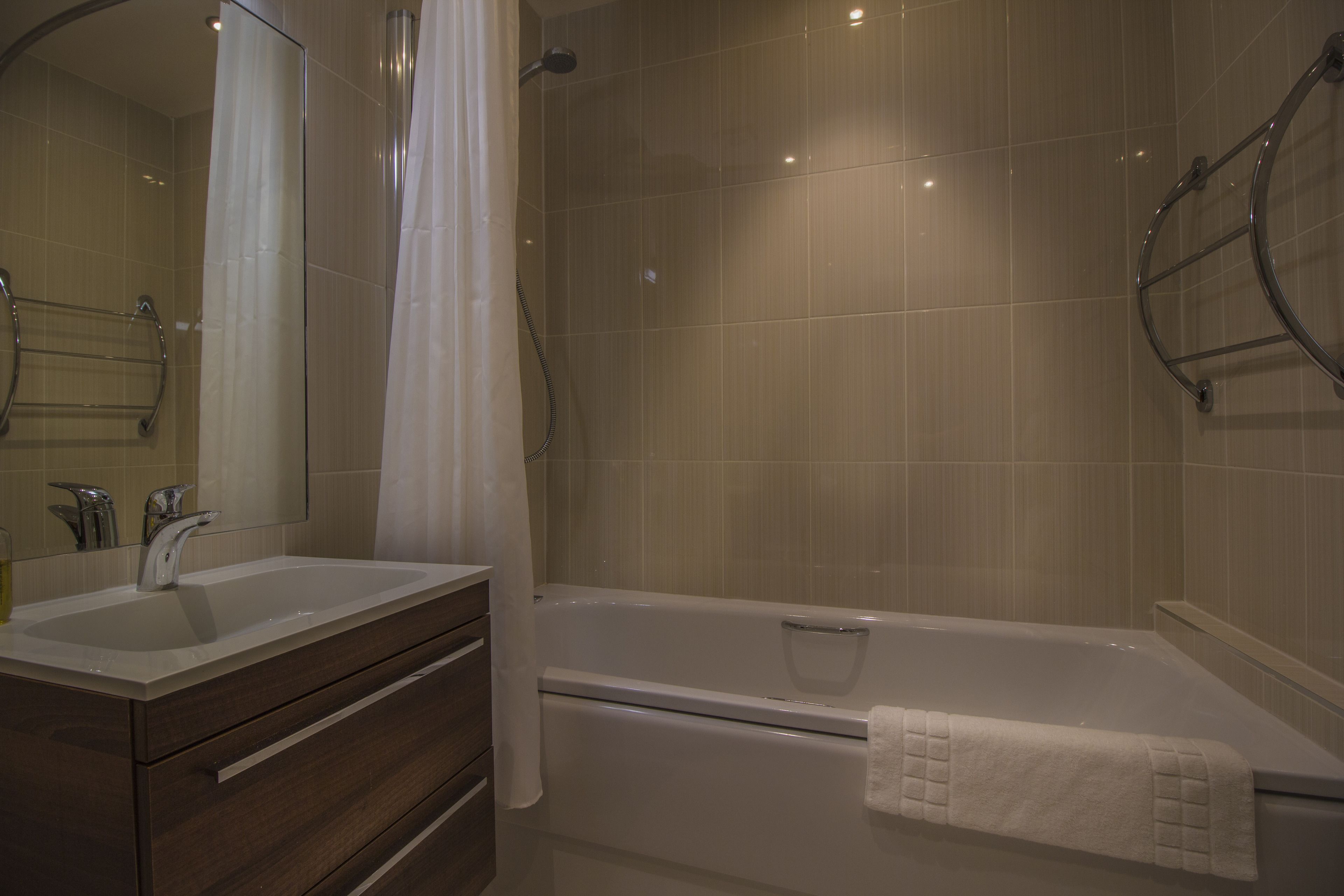 A bathroom with a double sink vanity, a bathtub, and a shower.