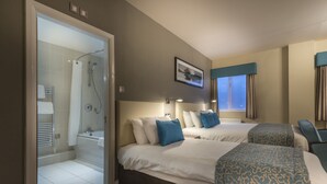 A hotel room with two beds, a shower, and a window with curtains. - The Three Swans Hotel, Market Harborough, Leicestershire (Market Harborough)
