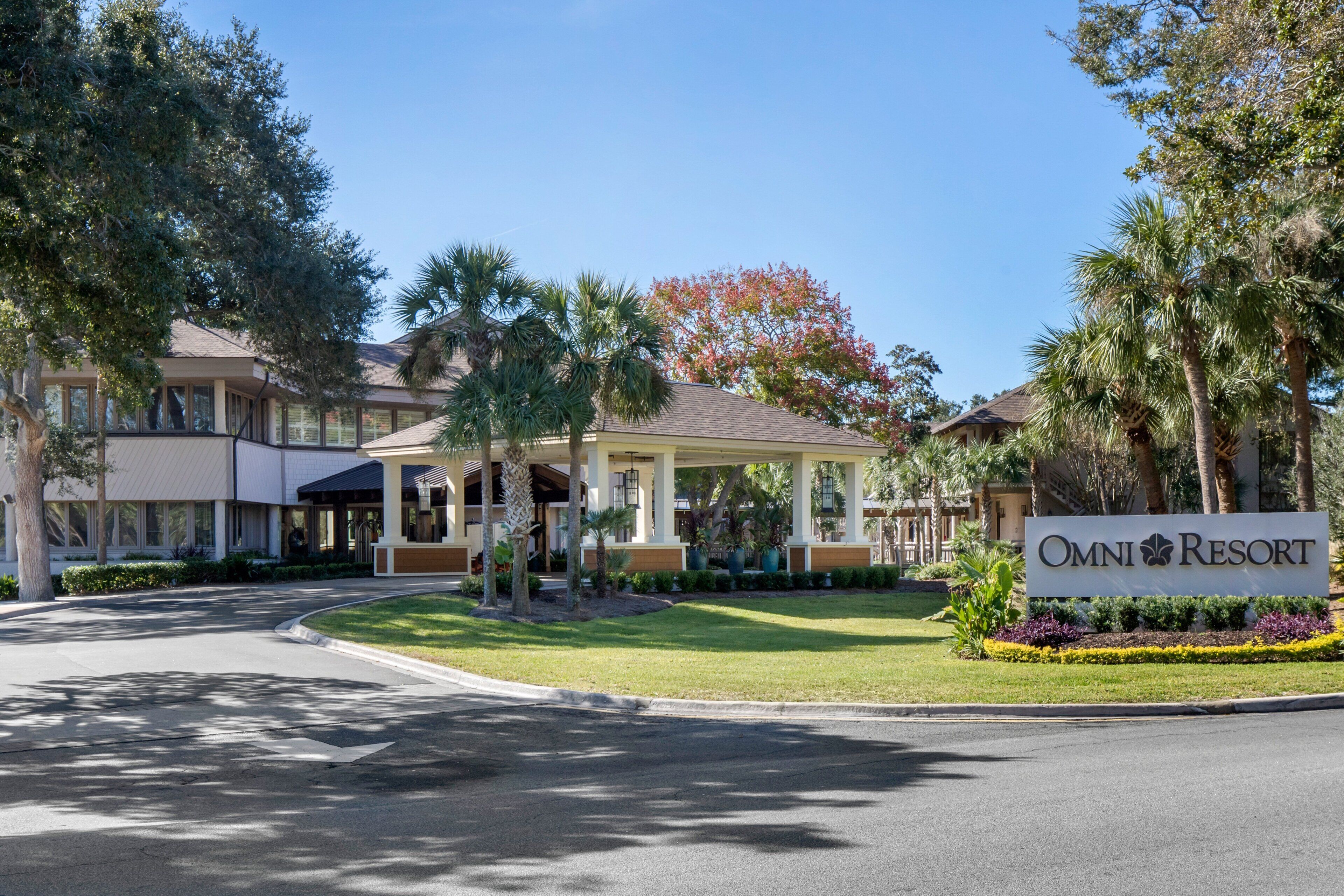 A hotel with a covered entrance, palm trees, and a sign reading "OMNI RESORT".
