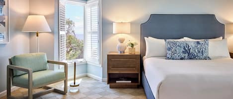 Une chambre à coucher avec un lit, une chaise, une table de chevet avec des lampes et une fenêtre avec des volets.