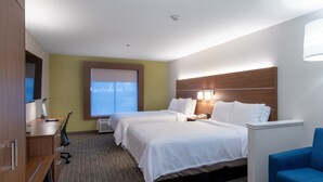 A hotel room with two beds, a desk, a chair, and a TV.