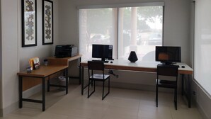 A modern office space with a desk, two chairs, a printer, and framed artwork on the wall. - Holiday Inn Express Arlington by IHG (Arlington)