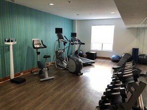 A gym with exercise equipment, a standing bike, and a window providing natural light. - Holiday Inn Express Arlington by IHG (Arlington)
