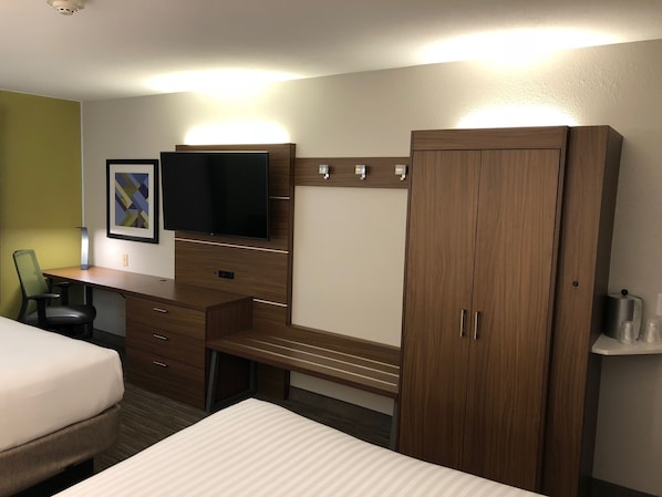 A hotel room with a bed, a desk with a flat-screen TV, a wardrobe, and a chair. - Holiday Inn Express Arlington by IHG (Arlington)