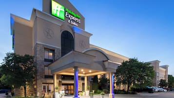 Edificio de Holiday Inn Express & Suites con un letrero llamativo, una entrada cubierta y un estacionamiento.