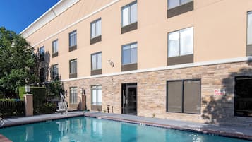 Un edificio moderno con piscina, varias ventanas y un letrero que indica 'No Diving'.