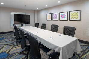 A conference room with a long table, chairs, a flat-screen TV, and framed artwork on the wall. - Holiday Inn Express Arlington by IHG (Arlington)